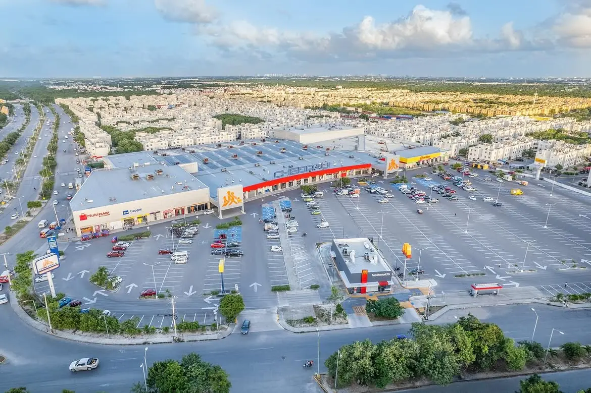 Vista aérea de una zona comercial rodeada por desarrollos habitacionales.